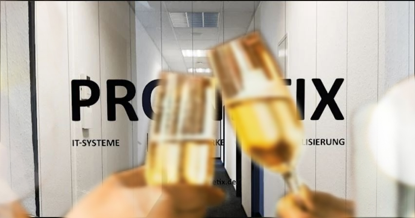 Zwei Menschen stoßen mit Sektgläsern vor der Bürotür von PRONETIX in Aachen an, im Hintergrund Flur und Eingang.